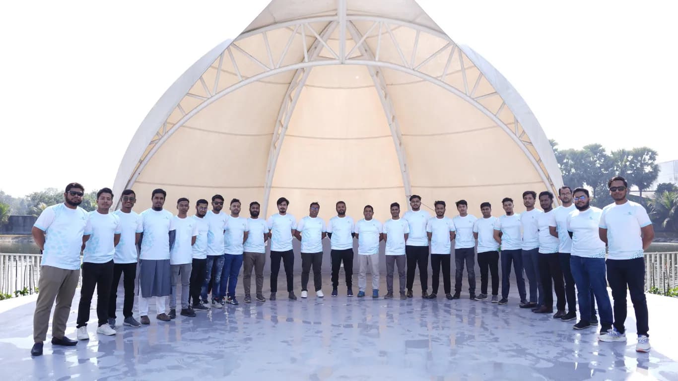 Team lined up in front of the white dome